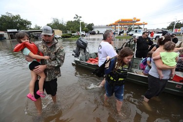 Neighbours use their personal boats to rescue Friendswood, Texas residents stranded by flooding Sunday, Aug. 27, 2017. =