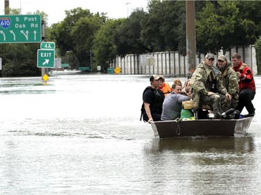 Residents are rescued from their homes surrounded by floodwaters from Tropical Storm Harvey on Sunday, Aug. 27, 2017, in Houston, Texas.