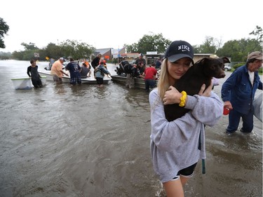 Mikhail Bachynsky hugs her dog Lily after they were rescued from their home Sunday, Aug. 27, 2017, in the Friendswood area of Houston. Neighbors with boats are using their personal boats to rescue Friendswood stranded by flooding.