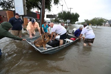 Neighbours are using their personal boats to rescue flooded Friendswood residents Sunday, Aug. 27, 2017, in Friendswood, Texas.