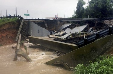 Waters rush from a large sinkhole on Highway FM 762 in Rosenberg, Texas, near Houston, Sunday, Aug. 27, 2017. Police say the sinkhole has opened on the Texas highway as Tropical Storm Harvey dumps more rain on the region.