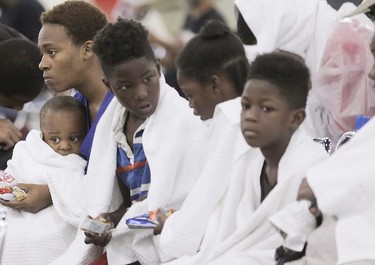 Terranysha Ferguson holds her son, Christian Phillips as she sits with the rest of her family at the George R. Brown Convention Center in Houston on Sunday, Aug. 27, 2017. Rising floodwaters from the remnants of Hurricane Harvey chased thousands of people to rooftops or higher ground Sunday in Houston, overwhelming rescuers who fielded countless desperate calls for help.