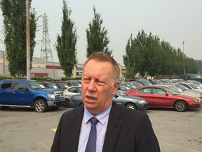 Insurance Corp. of B.C. president and CEO Mark Blucher talks to media at an event to launch a new road safety campaign. Behind him are 36 damaged cars, signifying the 36 crashes that happen every hour in B.C.