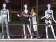 Virgilia Berzinis adjusts summer/fall crossover fashions on a mannequin in the window of Jordan Stewart Boutique on Richmond Row in London, Ont., on Aug. 15.