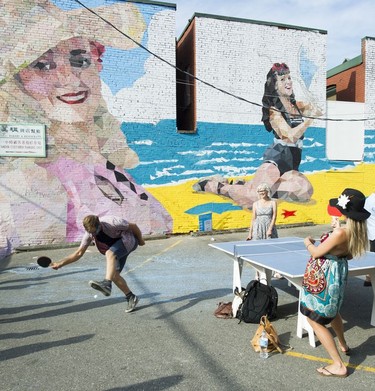 A table tennis table is set in front of a mural in a Main Street alley at the Vancouver Mural Festival.