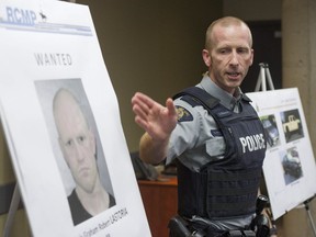 Surrey RCMP display drugs and guns they recovered from a long-term investigation. A total of 48 charges were laid against several people, one of whom is still wanted. Pictured is RCMP Cpl. Scotty Schumann.