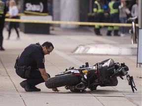A police officer makes markings around a motorcycle after a stunt rider crashed and went through a window on the set of Deadpool 2 in Vancouver, BC, August, 14, 2017. The stunt rider succumbed to her injuries.