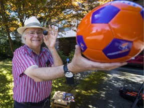 Dr. Stanley Greenspoon holds up a squash ball in front of a soccer ball to demonstrate how something as small as the moon can block out something as large as the sun. Greenspoon is travelling to Oregon to see Monday's total eclipse of the star.