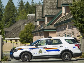 An RCMP vehicle blocks the access to a lane in the 6900-block between 127A and 128 Streets in Surrey after a body was discovered early Sunday morning.