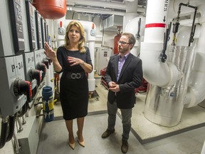 Then-Surrey mayor Dianne Watts, left, with the city's district energy manager, Jason Owen, tours the geothermal energy room in the basement of the new Surrey city hall in 2014.