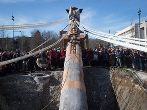 A blessing ceremony is performed before a Reconciliation Pole is raised at the University of British Columbia in Vancouver, B.C., on Saturday, April 1, 2017. The 17-metre red cedar pole tells the story of the time before, during and after the Indian residential school system. Thousands of copper nails representing thousands of Indigenous children who died in Canada's residential schools were hammered into the pole by survivors, affected families, school children and others. The totem pole faces the future site of the Indian Residential School History and Dialogue Centre.