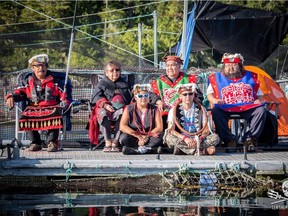 Protesters gather at the Marine Harvest fish farm on Swanson Island, near Alert Bay, in a handout photo from the Facebook page Swanson Occupation. Ernest Alfred, 36, sitting cross-legged on the right wearing a cedar bark neck ring, sits with other traditional leaders from neighbouring villages.