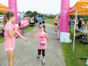 Young girls exchange high fives after finishing their race Sunday morning at the Rocky Mountain Soap Women's Run/Walk at Burnaby Lake Regional Park. There was a half marathon, 10K and 5K as well.