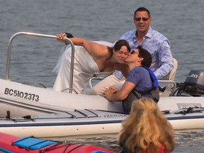 Prime Minister Justin Trudeau, front right, gives a kiss to new bride Michelle Gruetzner as her husband Heiner Gruetzner, back, watches after they came across Trudeau kayaking at Sidney Spit in the Gulf Islands National Park Reserve, while taking a boat to a wedding reception, east of Sidney, B.C., on Saturday August 5, 2017.