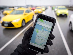 The Uber app is displayed on an iPhone as taxi drivers wait for passengers at Vancouver International Airport, in Richmond, B.C., on Tuesday, March 7, 2017. Uber has rolled out an in-app option for riders to tip their driver in five Canadian cities and plans to implement the feature across Canada and the U.S at the end of July.