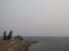 Thick smoke from wildfires fills the air as people stand on a beach on Kamloops Lake west of Kamloops, B.C., on Tuesday August 1, 2017.