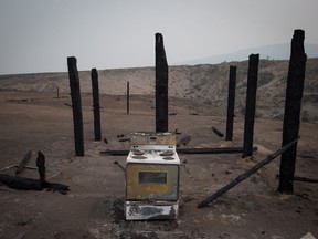 A stove sits among the remains of a structure that burned in a wildfire on the Ashcroft First Nation on July 6.