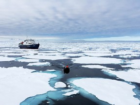 The Ortelius Expedition ship and a zodiac make their way through the Arctic ice pack.