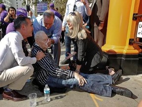 Los Angeles Mayor Eric Garcetti, left, comes to the aid of an unidentified man who collapsed in downtown Los Angeles Thursday, Aug. 31, 2017. The temperature in downtown Los Angeles shot past 90 degrees early in the day and a spectator collapsed just as Mayor Eric Garcetti was about to start a late-morning ceremony to mark the reopening of the city&#039;s historic Angels Flight funicular railroad. The man appeared to recover but was taken away by paramedics. (AP Photo/Damian Dovarganes)