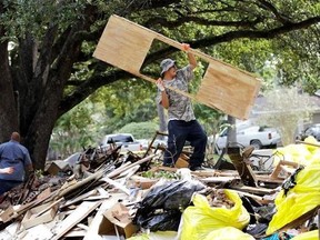 Rene Ramirez helps move debris from a home damaged by floodwaters in the aftermath of Hurricane Harvey on Wednesday, Sept. 6, 2017, in Spring, Texas. (AP Photo/David J. Phillip)