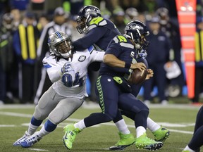 FILE - In this Jan. 7, 2017, file photo, Seattle Seahawks quarterback Russell Wilson, right, is pursued by Detroit Lions defensive end Ezekiel Ansah (94) as Ansah is blocked by Seattle Seahawks offensive tackle George Fant, center, in the first half of an NFL football NFC wild card playoff game, in Seattle. The Lions open their season on Sept. 10 against the Arizona Cardinals. (AP Photo/Stephen Brashear, File) ORG XMIT: NY167