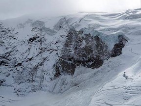 The glacial ice avalanche of the Trift Glacier above the village is pictured this morning in Saas-Grund, Valais, Switzerland, Sunday, Sept. 10, 2017. Part of the glacier has broken off and tumbled onto a glacier below after some 220 people in a small nearby town were evacuated as a precaution. (Dominic Steinmann/Keystone via AP)