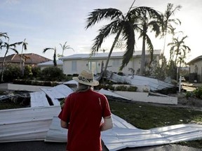 A roof is strewn across a home&#039;s lawn as Rick Freedman checks his neighbor&#039;s damage from Hurricane Irma in Marco Island, Fla., Monday, Sept. 11, 2017. (AP Photo/David Goldman)