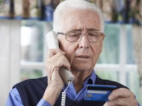 File photo: Phone scams —Senior man giving personal details over phone.