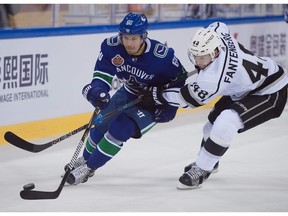 Markus Granlund of the Vancouver Canucks fights for the puck with Los Angeles Kings' Oscar Fantenberg during the 2017 NHL China Games in Beijing on Sept. 23, 2017.