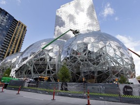 In this April 27, 2017 file photo, construction continues on three large, glass-covered domes as part of an expansion of the Amazon.com campus in downtown Seattle. Amazon said Thursday, Sept. 7, that it will spend more than $5 billion to build another headquarters in North America to house as many as 50,000 employees.