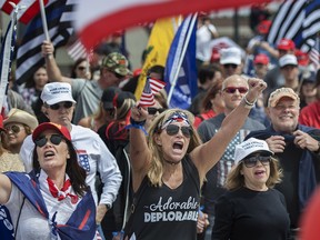 Wearing her "Adorable Deplorable" tee, Deanne Payn, center, with Sheila Ponce, left, take part in a pro-President Donald Trump rally in Huntington Beach, Calif., on Saturday, March 25, 2017.
