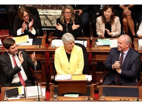 Attorney-General David Eby, left, and Premier John Horgan clap as B.C. Finance Minister Carole James is introduced before delivering the budget in Victoria on Monday, Sept. 11, 2017.