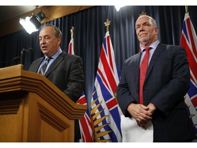 B.C. Green party Leader Andrew Weaver speaks to reporters as Premier John Horgan looks on following the legislation announcement banning union and corporate donations to political parties during a Monday news conference in Victoria.
