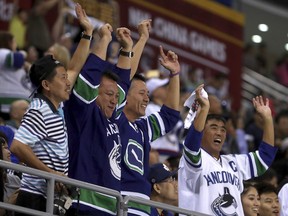 Vancouver Canucks fans cheer after the Canucks' scored a goal against the Los Angeles Kings during the third period of their NHL China exhibition game at the Cadillac Arena in Beijing, Saturday. The Kings won 4-3 in an overtime shootout.