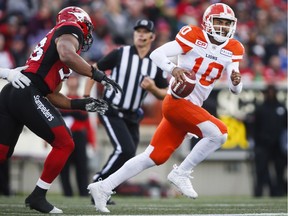 B.C. Lions quarterback Jonathon Jennings, right, runs from Calgary Stampeders' James Vaughters during first half CFL football action in Calgary on Saturday.