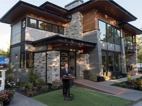 PNE president Mike McDaniel announces the winner of the 83rd PNE prize home Monday as Andy Bachler and Ming Lee of Surrey.