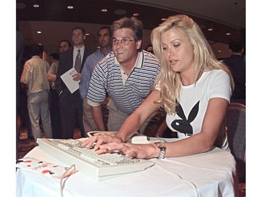 June 20, 2000: Playboy playmate Lisa Dergan joins in a game of poker through a new service being sold by Las Vegas from Home.com. Beside Dergan is Robert Arcand who was one of the business people on hand for the launching at the Four Seasons hotel in Vancouver.  Photo: Ward Perrin/Vancouver Sun