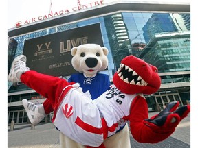 Carlton the Bear and The Raptor pose out front of the Air Canada Centre in Toronto. Scotiabank paid $800 million for a 20-year naming rights deal. As of July 1, 2018 the facility will be known as Scotiabank Arena.