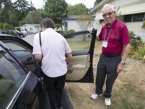 George Garrett helps Karon Peers get into Garrett's car before he takes her to a doctor appointment in Surrey. Garrett is a retired CKNW news reporter who volunteers his time driving cancer patients to and from appointments.