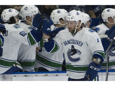 Vancouver Canucks Jonah Gadjovich celebrates with the team after scoring against the Winnipeg Jets.