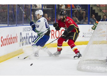 Calgary Flames Hunter Smith delivers a hit to Vancouver Canucks Olli Juolevi.