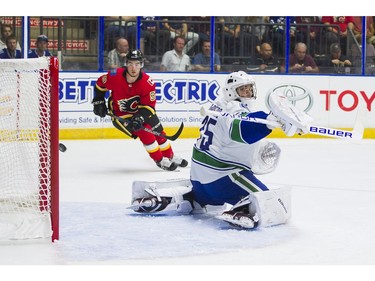 Vancouver Canucks goalie Michael DiPietro (right) and Calgary Flames Dillion Dube watches the puck hit the post during NHL preseason hockey action on Sunday, September 10.
