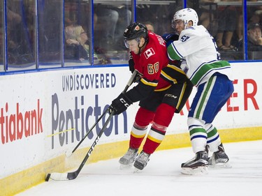 Calgary Flames Brett Pollock (left) gets checked by Vancouver Canucks Michael Carconei.