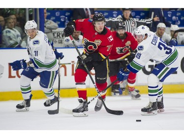 Calgary Flames Mark Jankowski (middle) slips through the defence of Vancouver Canucks Mackenze Stewart (left) and Johny Corneil (39).