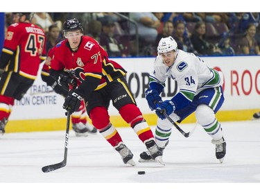 Calgary Flames Mark Jankowski makes a pass while being chased down by Vancouver Canucks Jakob Stukel (34).