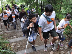 Participants in the Blind Grind Challenge in action on the Grouse Grind in North Vancouver on Sunday. Nine blind young people climbed the Grind with the help of sighted guides