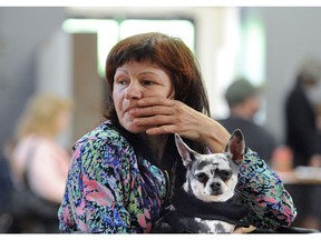 Iryna Zemlinska and her dog Luna wait as Paws for hope volunteers help homeless and low income pet owners Sunday in New Westminster.