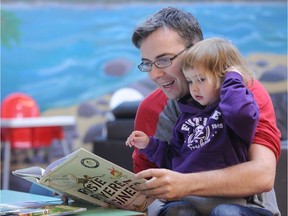 Denis Ryan and his daughter Ada reading at the Marpole Community Centre in Vancouver.