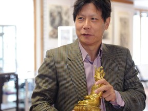 Dichen Hu, Jade d’Art’s chief executive officer and appraiser, holds a Ming gilded-bronze Buddha dating back more than 600 years, in Steveston on Sept. 25.