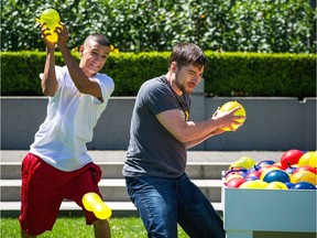 Passerbys get into an impromptu water balloon fight at Harbour Green Park in Vancouver Tuesday, July 16, 2013.